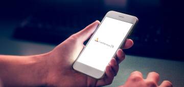 Dłoń trzyma smartfon z białym ekranem