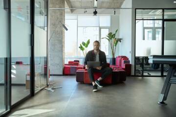 Nowoczesne biuro i praca Kobieta siedzi w nowoczesnym biurze, pracuje na laptopie