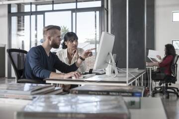 Wspólna praca nad projektem Mężczyzna i kobieta omawiają projekt na laptopach i planszach