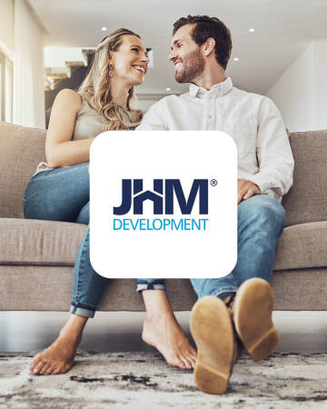 JHM Development — para w domu Uśmiechnięta para z logo JHM Development na tle salonu