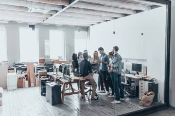 Biuro coworkingowe z ludźmi przy stanowiskach pracy