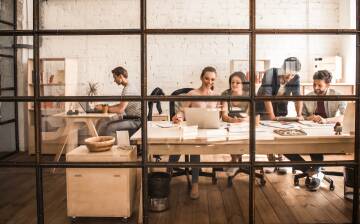 Nowoczesne biuro open space, zespół pracuje przy komputerach